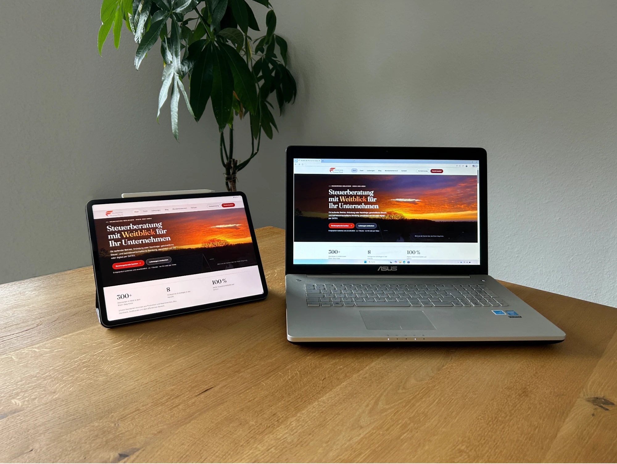 Tablet und Laptop auf einem Holztisch, beide zeigen die Startseite der Kanzlei-Website – digitale Zusammenarbeit